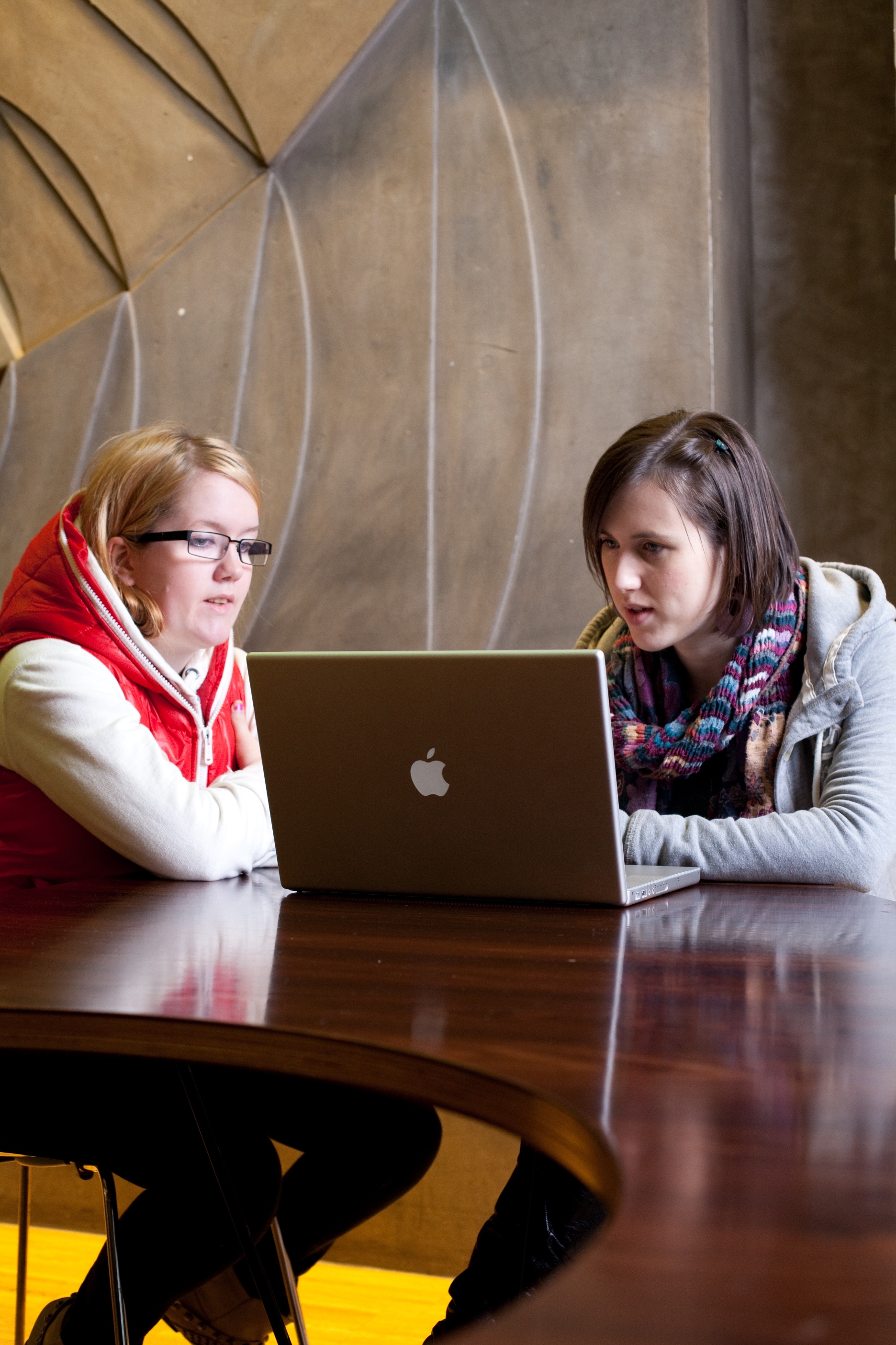 Two Welsh students work at a laptop