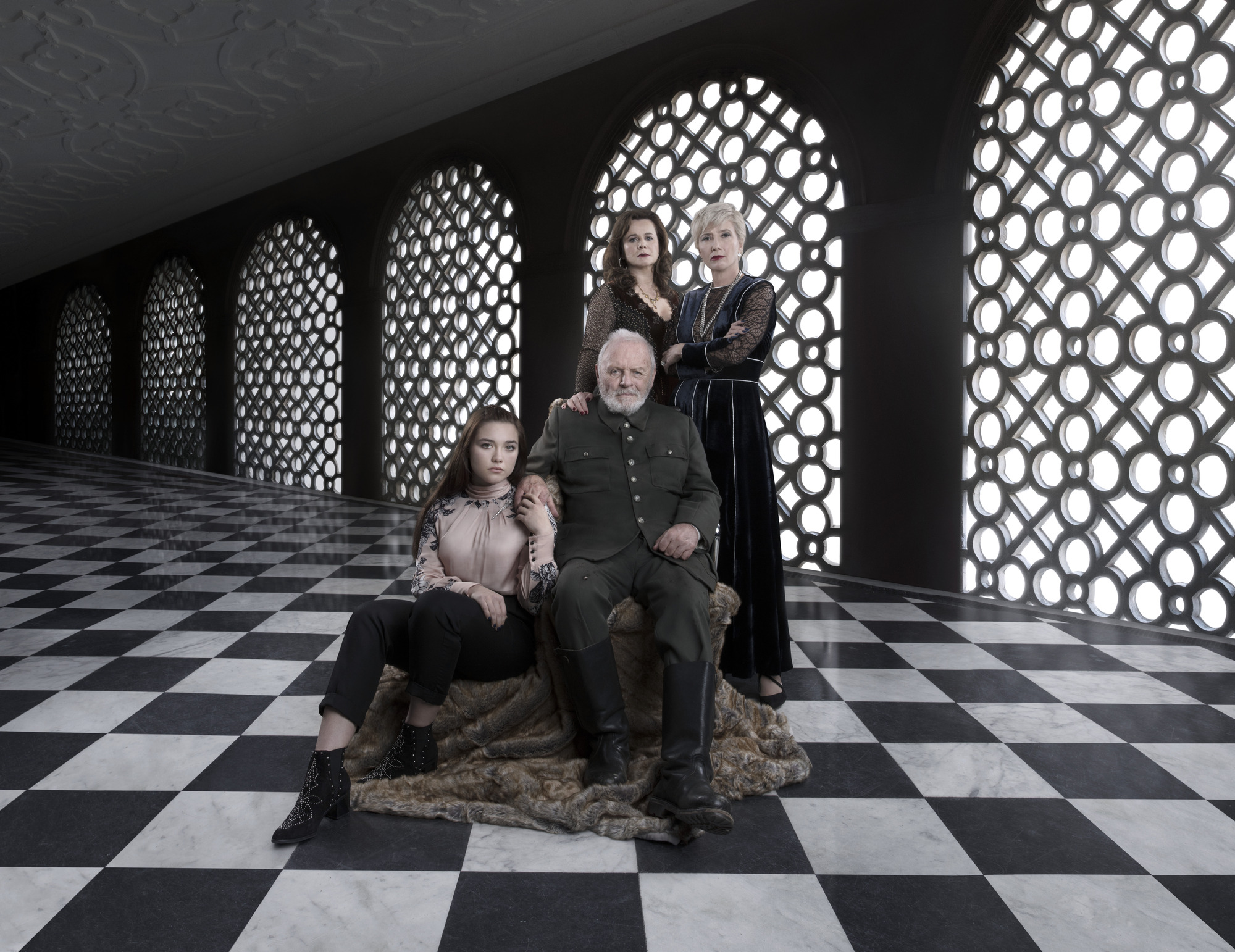 King Lear on his throne as his daughters surround him