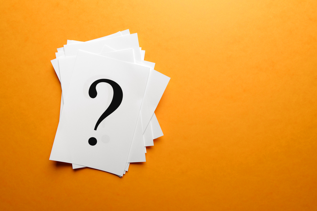 Question mark on white paper with a bright orange background